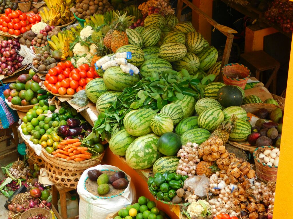 Fresh fruit and vegetables piled at a Ugandan market stall