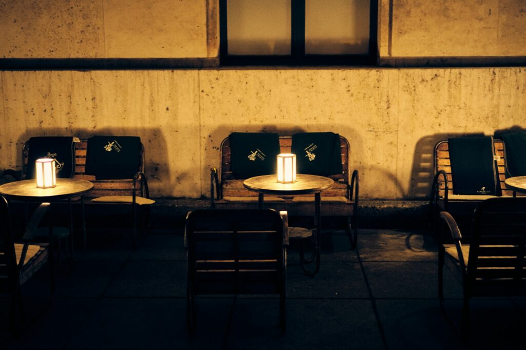 Outdoor seating glowing with table lamps at dusk